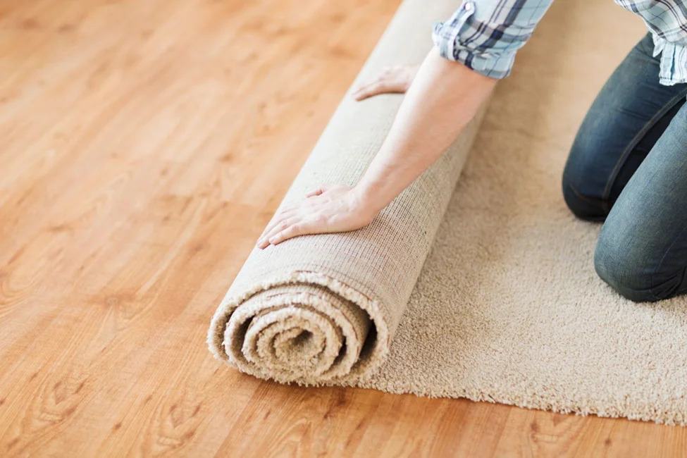 Woman rolling up carpet